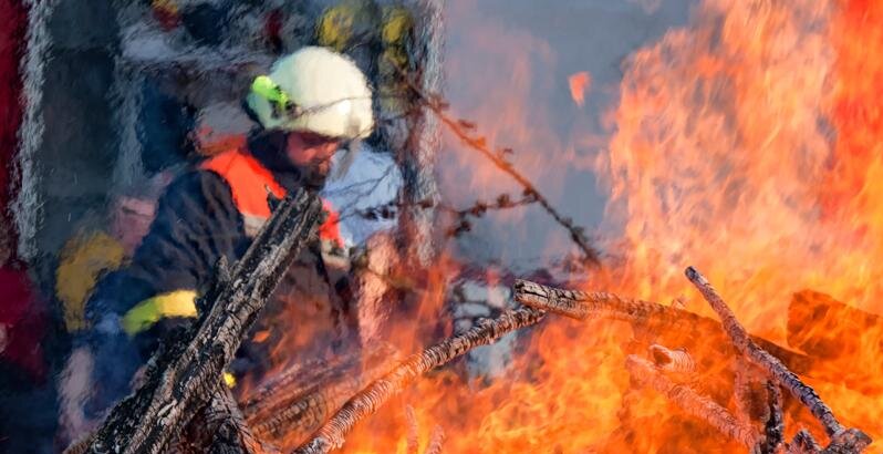 Das Symbolbild zeigt eine Feuerwehrmann beim Löschen eines Brandes