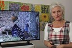 Barbara Geiger neben einem Bildschirm mit dem Schriftzug "Fräulein Brehms Tierleben"